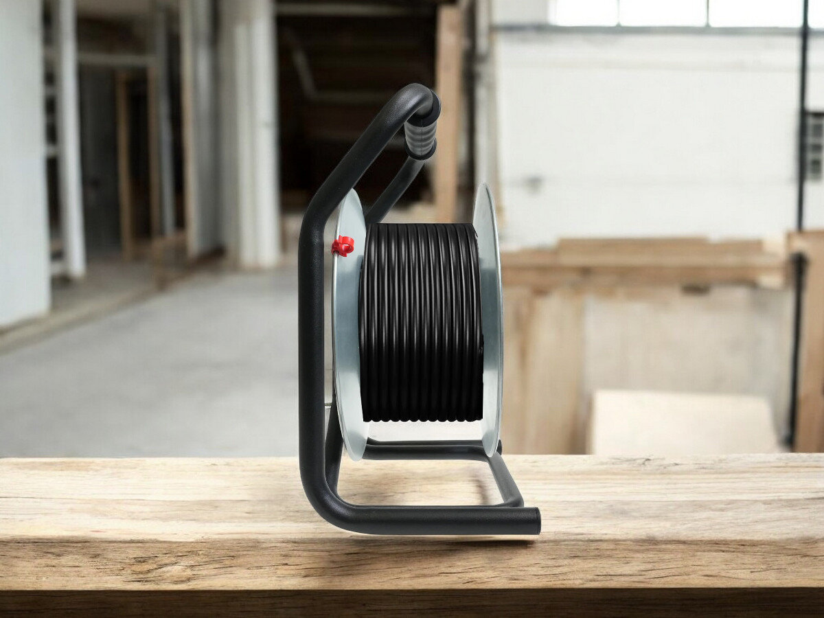 Przedłużacz bębnowy BORBY BY-02-36539 (30 m), praca, przewód, gniazda, trwałość, przedłużacz od boku frontem na wprost z nawiniętym kablem, w tle trwają prace remontowo-budowlane