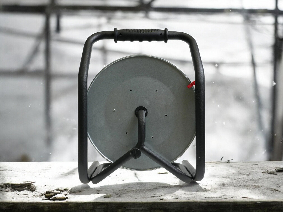 Przedłużacz bębnowy BORBY BY-02-36539 (30 m), ochrona, wyłącznik, IP44, wygoda, przedłużacz od tyłu pionowo frontem na wprost, w tle trwająca prace remontowo-budowlane