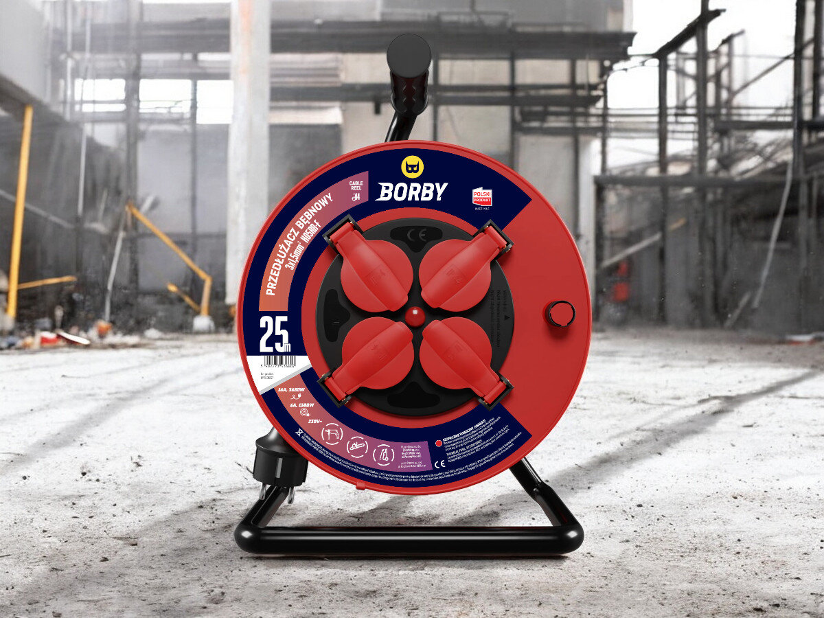 Przedłużacz bębnowy BORBY BY-02-36607 (25 m), solidne, odległość, zasięg, dystans, przedłużacz frontem na wprost z 4 wejściami stoi, w tle trwają prace remontowo-budowlane