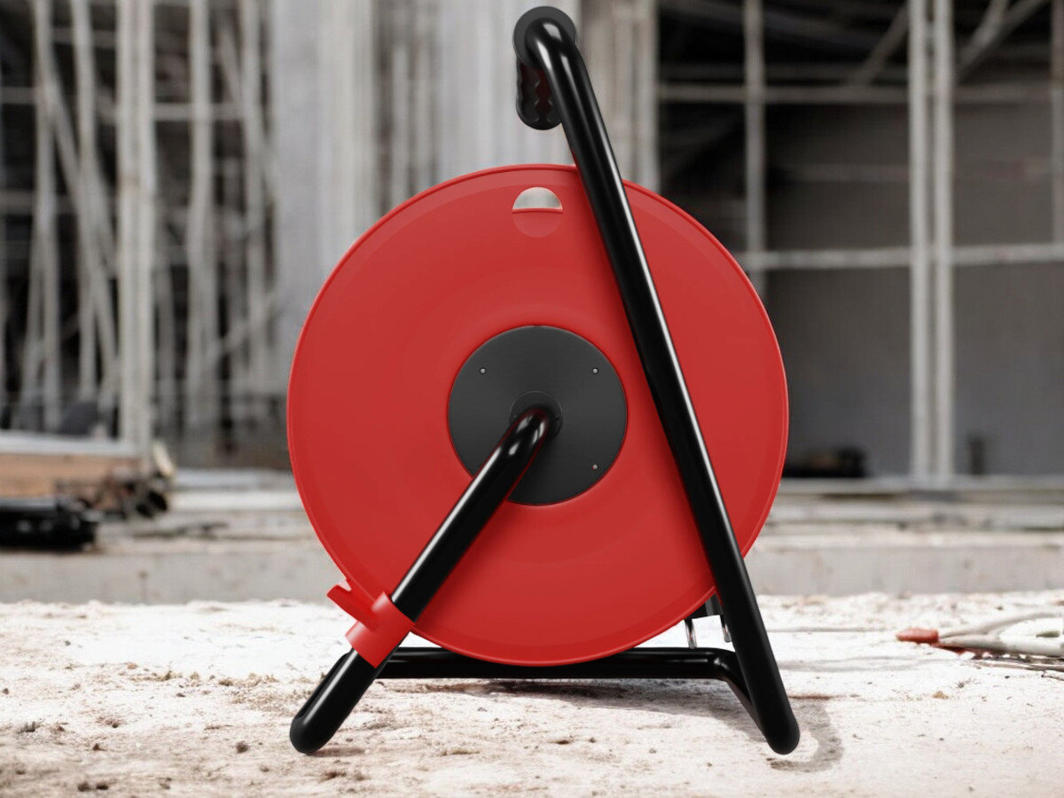 Przedłużacz bębnowy BORBY BY-02-36614 (30 m), gumowa, izolacja, IP44, blokada, nieruchome, przedłużacz od tyłu pionowo frontem na wprost, w tle trwająca prace remontowo-budowlane