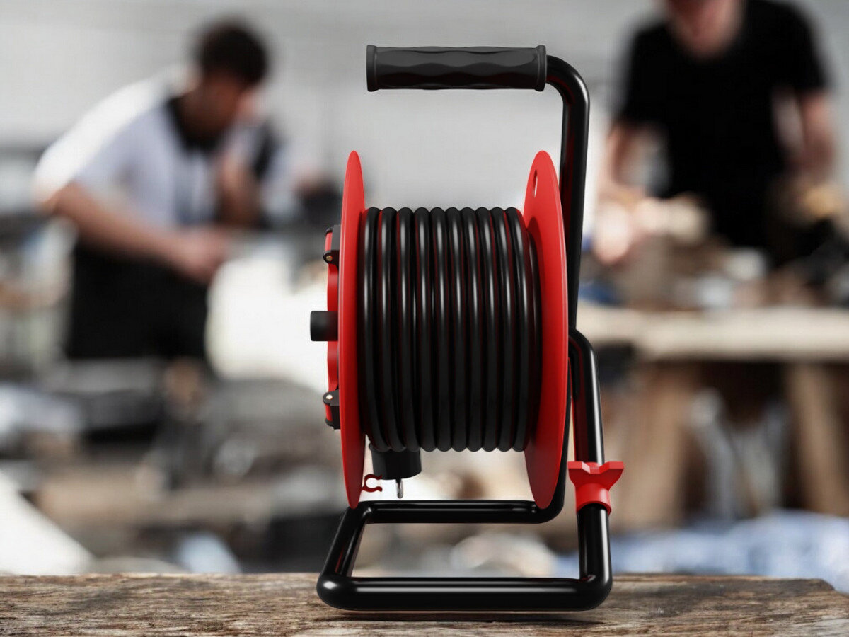 Przedłużacz bębnowy BORBY BY-02-36591 (20 m), moc, żyłka, przekrój, zasilanie, przedłużacz od boku frontem na wprost z nawiniętym kablem, w tle trwają prace remontowo-budowlane