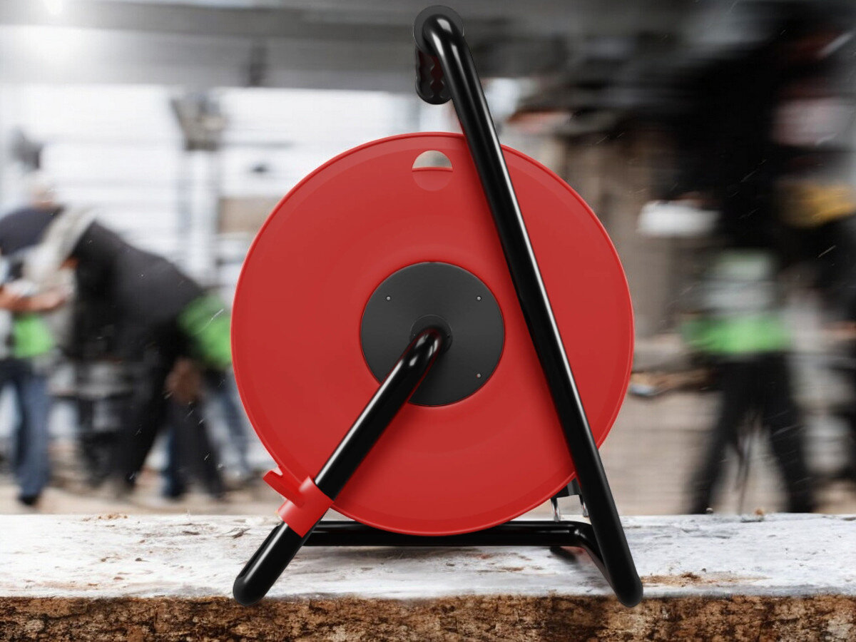 Przedłużacz bębnowy BORBY BY-02-36591 (20 m), gumowa, izolacja, IP44, blokada, nieruchome, przedłużacz od tyłu pionowo frontem na wprost, w tle trwająca prace remontowo-budowlane