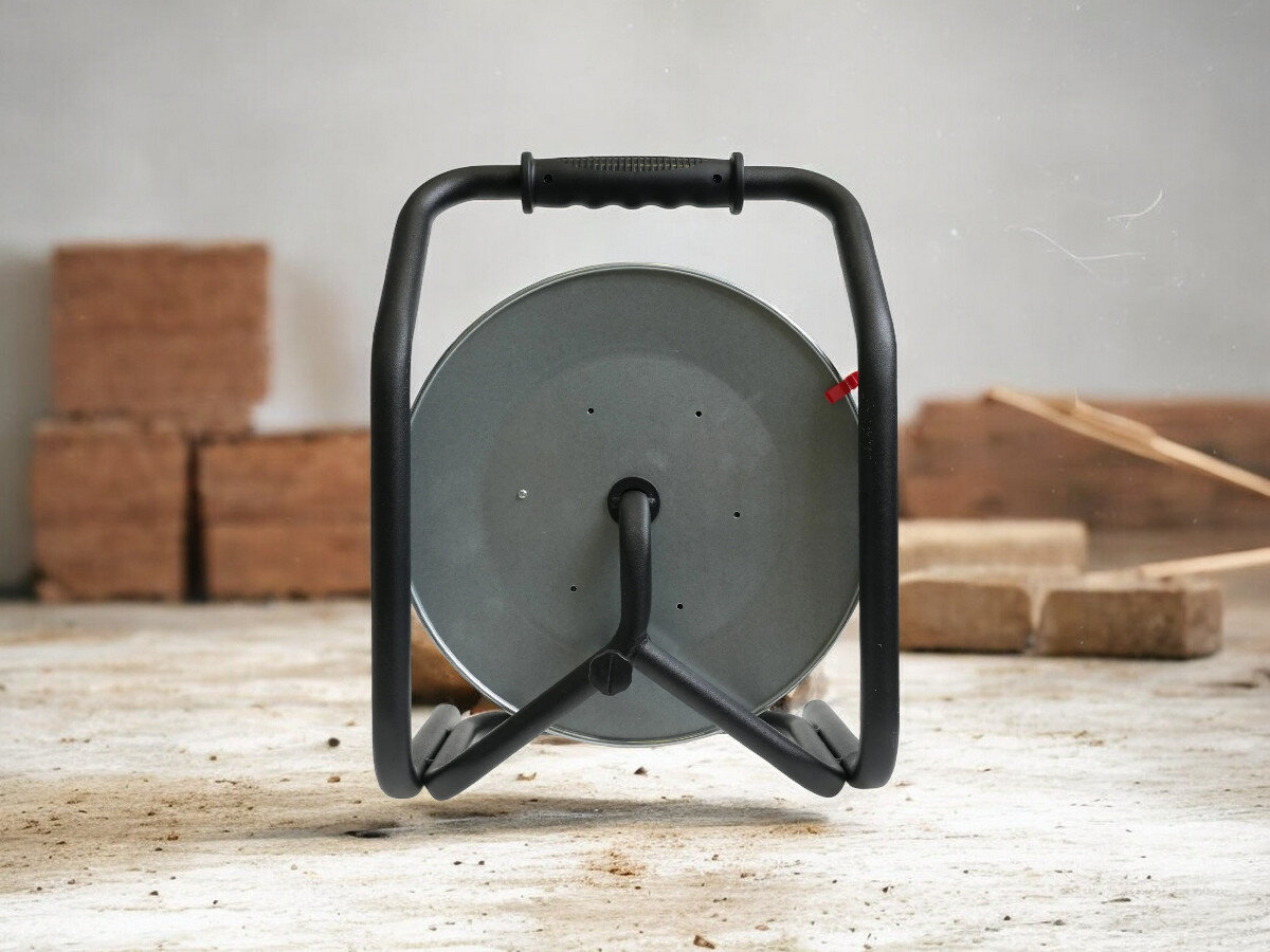 Przedłużacz bębnowy BORBY BY-02-36492 (20 m), ochrona, wyłącznik, IP44, wygoda, przedłużacz od tyłu pionowo frontem na wprost, w tle trwająca prace remontowo-budowlane