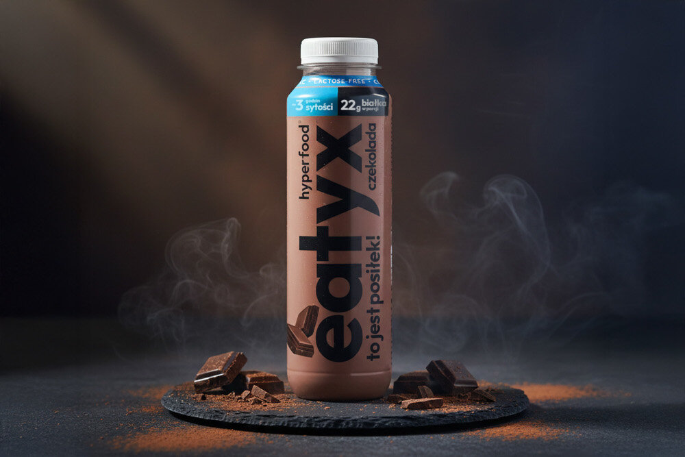 Posiłek w płynie EATYX Hyperfood Czekoladowy (300 ml) ciemne tło butelka ustawiona na czarnym płaskim kamieniu wokół butelki owoce Czekoladowy posiłek w płynnie zbilansowany posiłek zdrowie