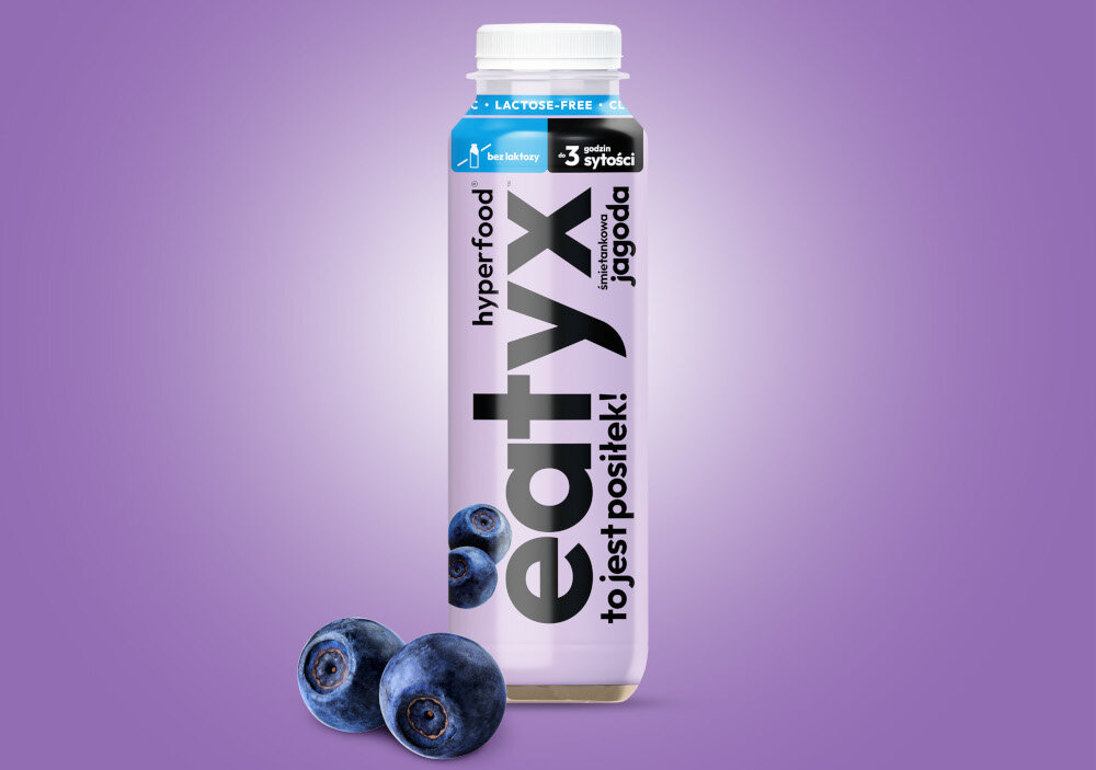Posiłek w płynie EATYX Hyperfood Śmietankowo-jagodowy (300 ml) butelka posiłku na fioletowym tle obok owoce jagód 22 witamin i minerałów biotyna (8.4 µg) witamina B12 (0,6 µg) chrom (6,6 µg) selen (9,3 µg) cynk (3,3 mg) wapń (570 mg) wspierają zdrowie skóry, włosów, paznokci i metabolizmu energetycznego