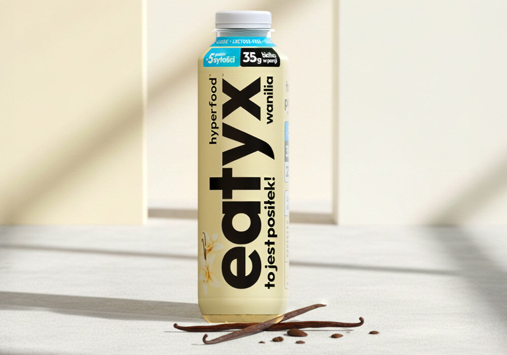 Posiłek w płynie EATYX Hyperfood Waniliowy (500 ml)  podłoga butelka stoi na podłodze obok butelki leżą laski wanilii jasne tło olej słonecznikowy źródło kwasów omega-6 i witaminy E chroni komórki przed stresem oksydacyjnym oraz wspiera serce, skórę i odporność węglan wodorotlenku magnezu magnez niezbędny dla kości, mięśni i układu nerwowego