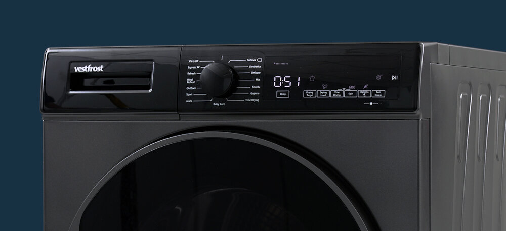 Suszarka VESTFROST VT-FD4EHY70EU Na zdjęciu przedstawiono górną część suszarki bębnowej Vestfrost z czytelnym panelem sterującym i pokrętłem programów. Urządzenie ma elegancki, ciemny front i wyprofilowane boczne ścianki, podkreślające design programy suszenia do bawełny do syntetyków program szybki Shirts 20 Express 34 program Refresh suszenie jeans suszenie outdoor wiele programów