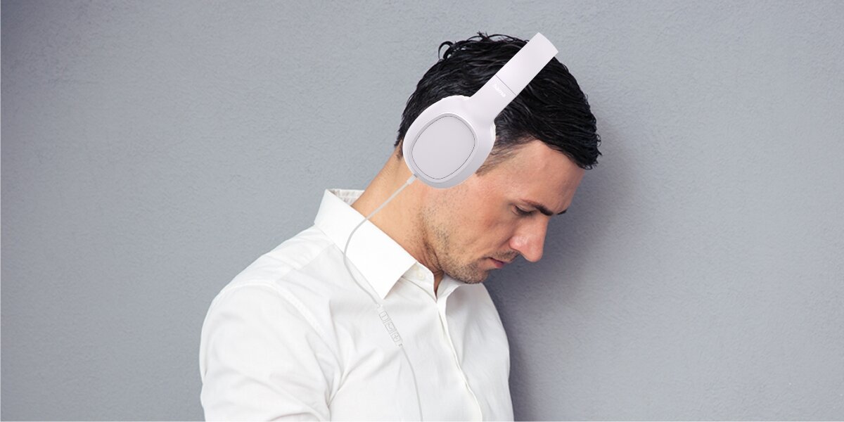 Słuchawki nauszne HAMA Fun C Biały Mężczyzna w białej koszuli korzystający ze słuchawek nagłownych Hama z mikrofonem na kablu, idealnych do pracy biurowej i wideokonferencji.