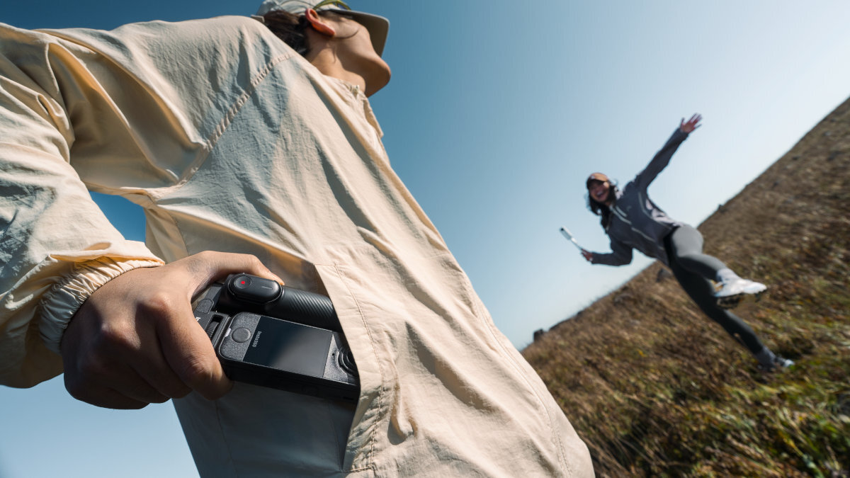 INSTA360 X4 Air INSTA360 X4 Air kamera 360° torbie lub kieszeni 114 x 46 x 37 mm 165 g vlogów i podróży osoba trzyma kamerę 360 stopni, druga skacze na tle błękitnego nieba i trawy