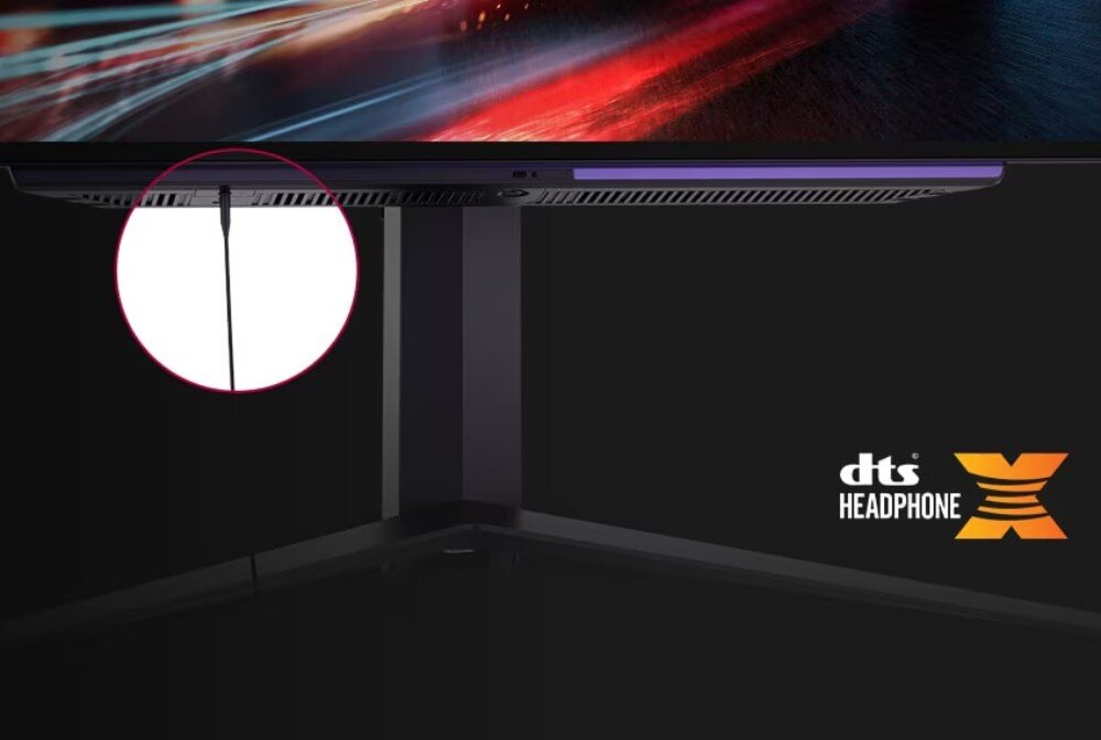 Monitor LG UltraGear 27GS95QE-B.AEU Zbliżenie na dolną część monitora, do którego podłączony jest przewód słuchawkowy. Logo technologii DTS Headphone:X w rogu, złącze słuchawkowe, dźwięk przestrzenny