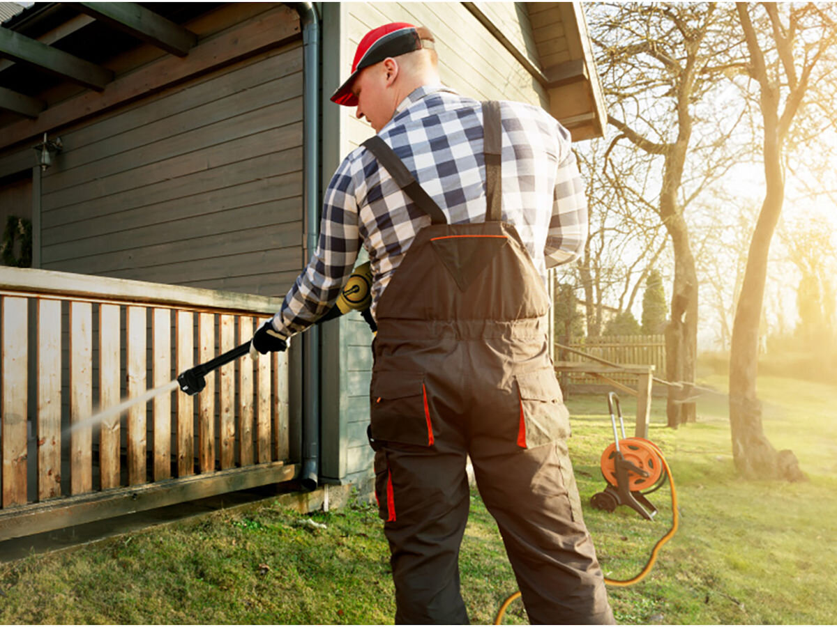 Myjka ciśnieniowa IMOU GYQXJ, Ergonomiczna, konstrukcja, manewrowanie, ręce, mężczyzna czyści płot domku myjką ciśnieniową