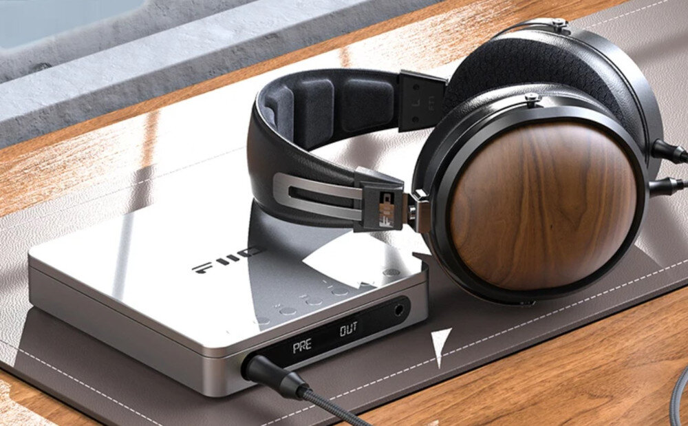 FIIO DM13 BT wyjście 660 mW słuchawki głośniki, przenośny odtwarzacz CD leżący na macie wraz z podłączonymi do niego słuchawkami nausznymi