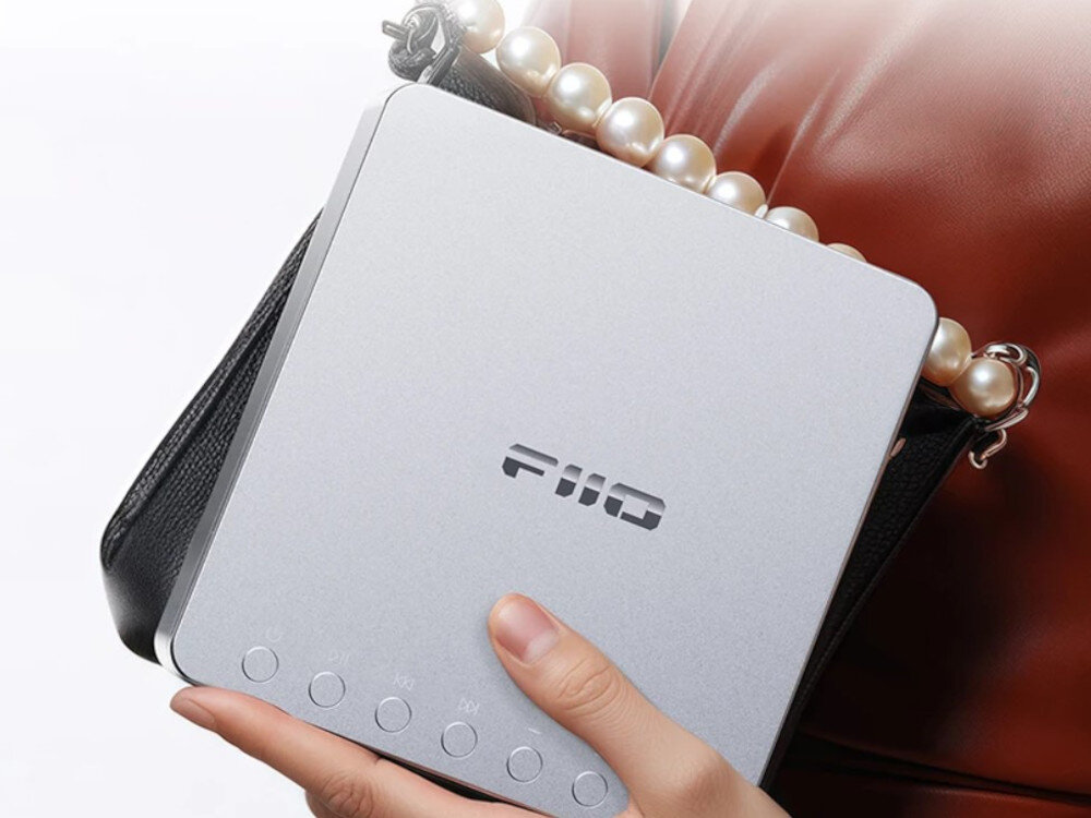 FIIO DM13 BT wyjścia cyfrowe optyczne koncentryczne DAC, osoba niosąca odtwarzacz wraz z torebką