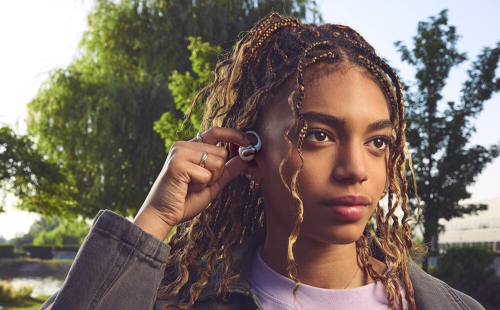 Słuchawki powietrzne JBL Sense Pro Hi-Res Audio Wireless LDAC adaptacyjny bas, osoba z założonymi słuchawkami na świeżym powietrzu