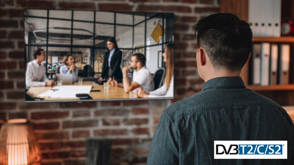 Telewizor JVC LT-55VG7500 tuner DVB-T2/C/S2 HEVC odbiór telewizja jakość, telewizor zawieszony na ścianie w pomieszczeniu