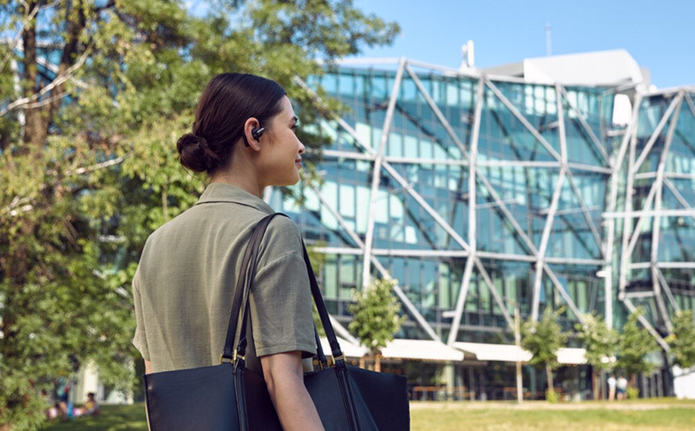 Słuchawki powietrzne JBL Sense Pro technologia OpenSound i wygodna konstrukcja, osoba z założonymi słuchawkami na świeżym powietrzu