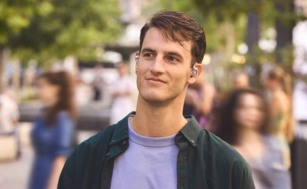 Słuchawki powietrzne JBL Sense Pro technologia OpenSound i wygodna konstrukcja, osoba z założonymi słuchawkami na świeżym powietrzu