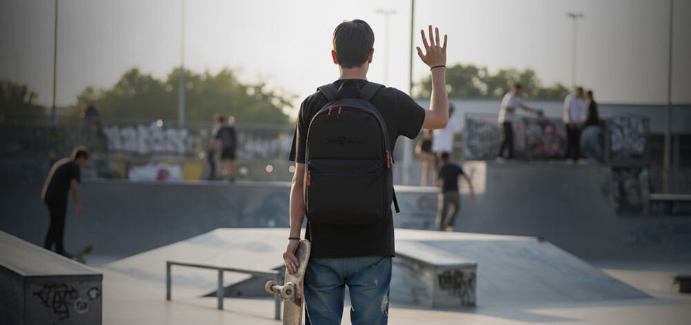 Plecak na laptopa GENESIS Pallad 200 14.1 cali Czarny prezentacja plecaka założonego na chłopaku w tle skatepark waga lekki plecak pojemne komory dedykowana przegroda na laptopa utrzymanie porządku przemyślana konstrukcja