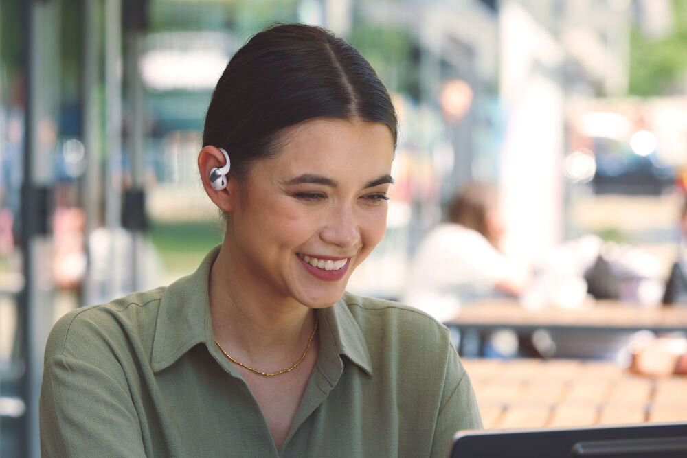 Słuchawki powietrzne JBL Sense Pro OpenSound Spatial Sound kontakt z otoczeniem, osoba z założonymi słuchawkami na świeżym powietrzu