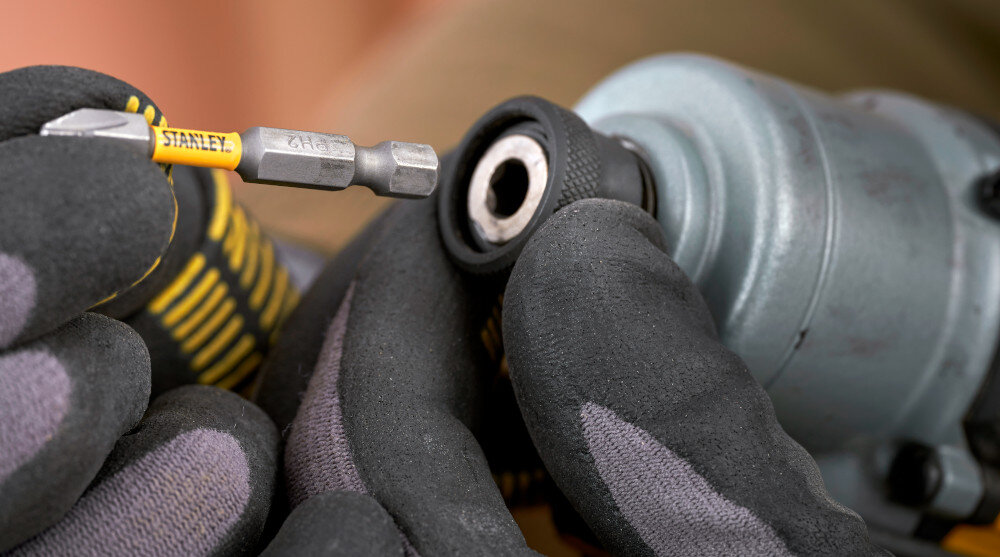 Zestaw elektronarzędzi STANLEY Fatmax SFMCK211D2T-QW zbliżenie na uchwyt w zakrętarce gumowana rękojeść stabilność chwytu mechanizm Drop ’n’ Load wymiana bitów jedną ręką płynność wykonywanych czynności