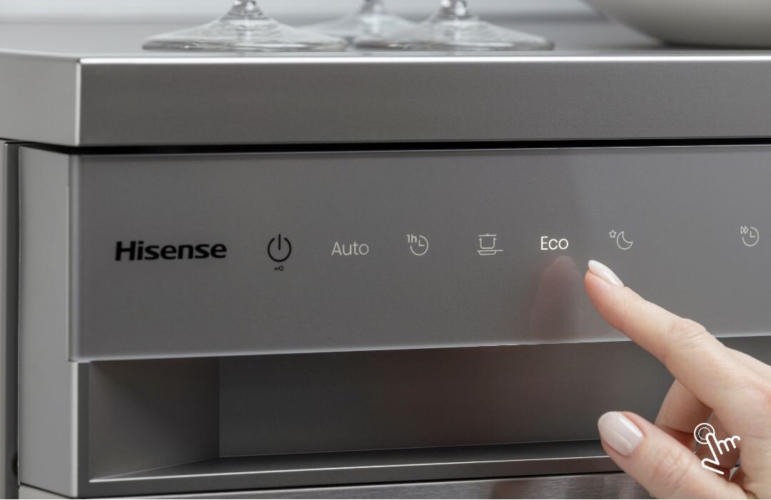 Panel sterowania zmywarki z widocznymi przyciskami: Hisense, włącznik, Auto, 1h, Eco. Palec wskazuje na przycisk Eco.