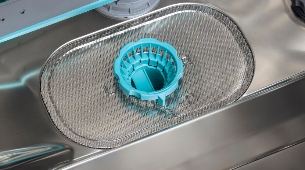 ZMYWARKA HISENSE HS693A90XAD Na dnie komory zmywarki widoczny jest duży, owalny filtr ze stalowej siatki. W jego centralnej części znajduje się turkusowy, okrągły element z przegrodą, służący do wygodnego wyjmowania i blokowania filtra filtr samoczyszczący łatwa konserwacja oszczędność czasu