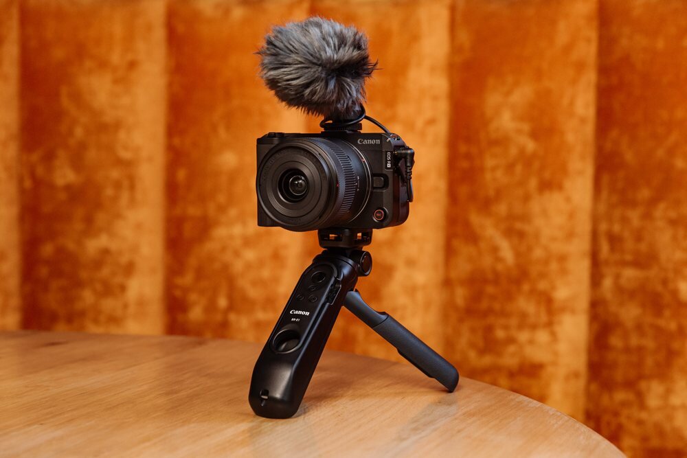 Aparat CANON EOS R50 V na statywie na stole