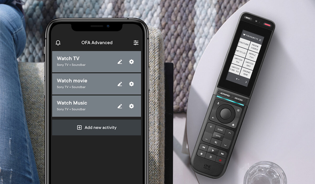 Na obrazie widoczny jest smartfon z aplikacją \'OFA Advanced\' oraz pilot z wyświetlaczem i przyciskami. Na ekranie smartfona widoczne są opcje: \'Watch TV\', \'Watch movie\', \'Watch Music\' oraz \'Add new activity\'.