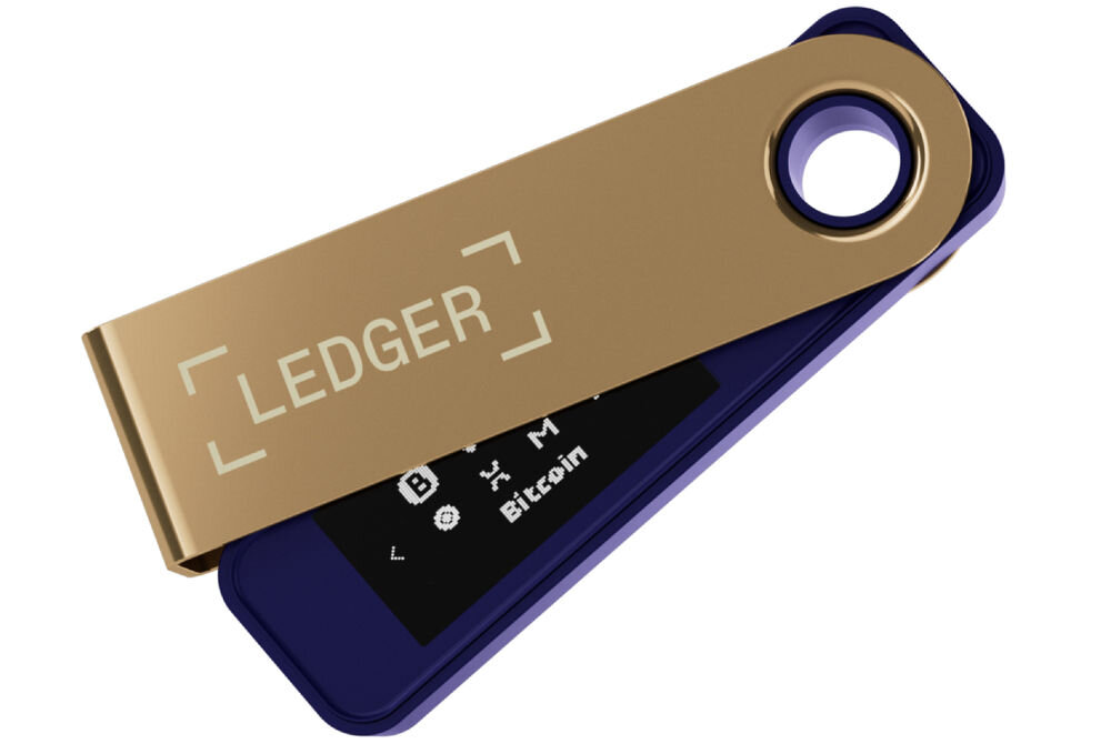 Portfel kryptowalut LEDGER Nano S Plus Sprzętowy portfel kryptowalutowy Ledger Nano S Plus w kolorze granatowo-złotym, z metalową osłoną częściowo odsuniętą, ukazującą wyświetlacz z ikonami kryptowalut i napisem Bitcoin. Na osłonie widoczne logo LEDGER.