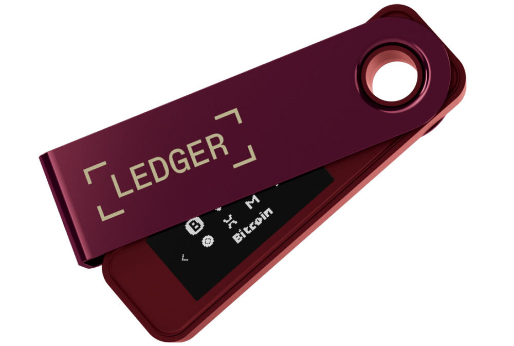 Portfel kryptowalut LEDGER Nano S Plus Sprzętowy portfel kryptowalutowy Ledger Nano S Plus w kolorze bordowym, z metalową osłoną częściowo odsuniętą, ukazującą wyświetlacz z ikonami kryptowalut i napisem Bitcoin. Na osłonie widoczne logo LEDGER.