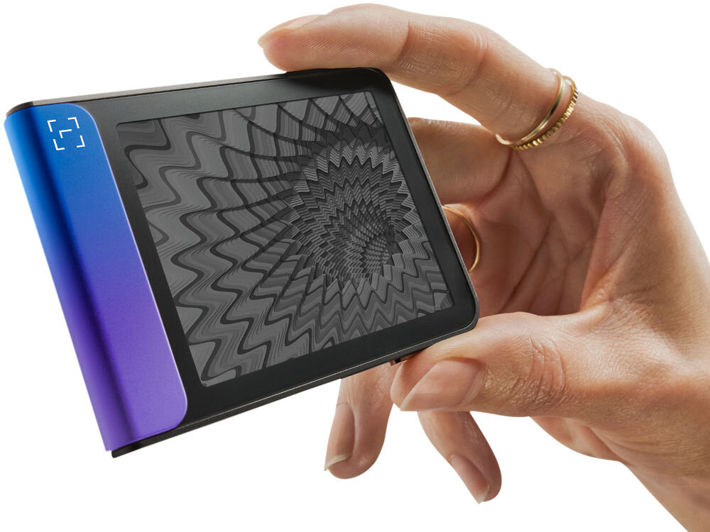 Portfel kryptowalut LEDGER Flex Zbliżenie na Ledger Stax trzymany w dłoni, pokazujące dynamiczną grafikę o hipnotycznym, falistym wzorze na ekranie e-ink (papier elektroniczny). Urządzenie jest zwrócone bokiem, eksponując jasny zielono-turkusowy element.