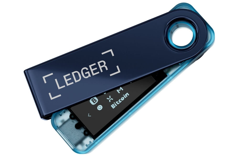 Portfel kryptowalut LEDGER Nano S Plus Sprzętowy portfel kryptowalutowy Ledger Nano S Plus w kolorze błękitnym, z metalową osłoną częściowo odsuniętą, ukazującą wyświetlacz z ikonami kryptowalut i napisem Bitcoin. Na osłonie widoczne logo LEDGER.
