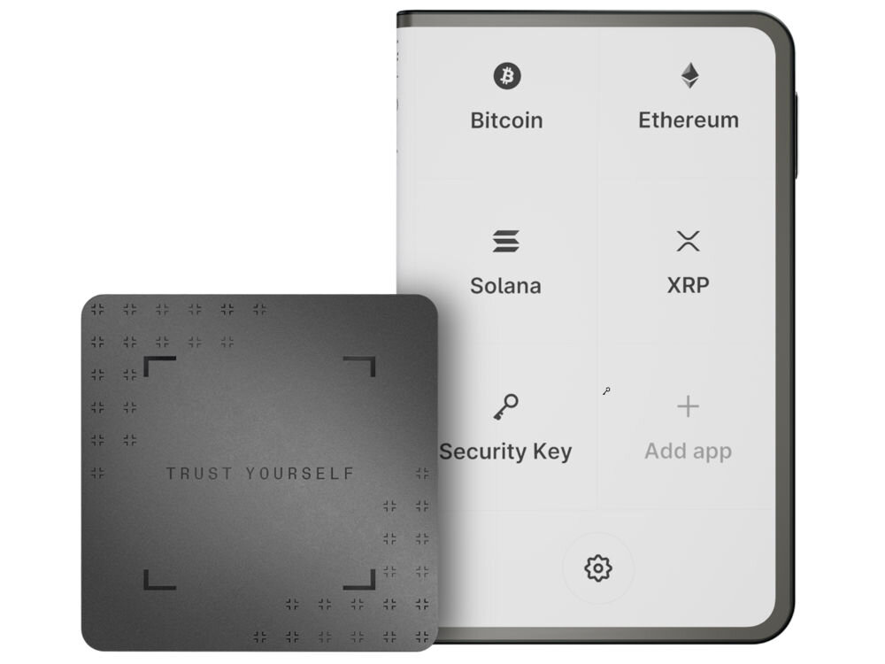 Portfel kryptowalut LEDGER Stax Crypto Hardware Wallet + Klucz odzyskiwania Portfel sprzętowy Ledger Stax z jasnym ekranem E Ink wyświetlającym główne menu: Bitcoin, Ethereum, Solana, XRP, Security Key i Add app. Obok urządzenia, po lewej stronie, leży karta Ledger Recovery Card z hasłem TRUST YOURSELF i ozdobnymi symbolami.