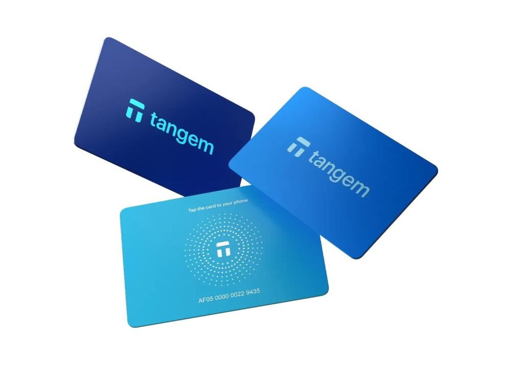 Pastelowe karty Tangem w kolorach fioletowym, różowym i turkusowym są ułożone wachlarzowo na białym tle - portfel kryptowalutowy w formie trzech kart 