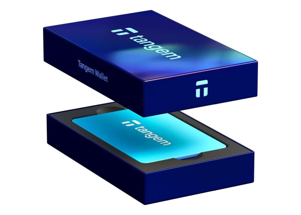 Pastelowa karta Tangem leży w białym pudełku zestawu Tangem Wallet z uniesionym wieczkiem - Karta Tangem komunikuje się ze smartfonem wyłącznie przez NFC  