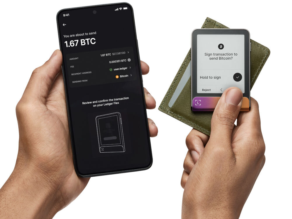 Portfel kryptowalut LEDGER Flex Demonstracja użycia Ledger Stax do autoryzacji transakcji kryptowalutowej. Jedna dłoń trzyma smartfon z widoczną aplikacją Ledger Live, pokazującą szczegóły transakcji Bitcoina (np. 1.67 BTC). Druga dłoń trzyma Stax, na którego ekranie widać prośbę o potwierdzenie transakcji: Sign transaction to send Bitcoin (Podpisz transakcję, aby wysłać Bitcoin) z opcją Hold to sign (Przytrzymaj, aby podpisać) i Reject (Odrzuć)