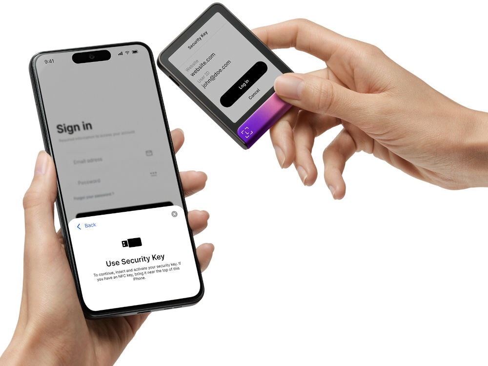 Portfel kryptowalut LEDGER Flex Zastosowanie Ledger Stax jako klucza bezpieczeństwa (Security Key). Ręce zbliżają Stax do smartfona, na którym wyświetla się ekran logowania oraz instrukcja Use Security Key (Użyj Klucza Bezpieczeństwa) sugerująca użycie NFC. Ekran Stax pokazuje interfejs logowania do strony internetowej.