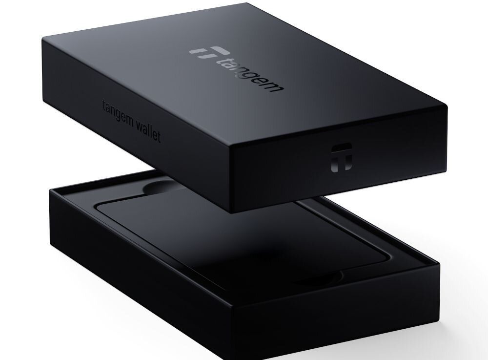 Karta Tangem leży w białym pudełku zestawu Tangem Wallet z uniesionym wieczkiem - Karta Tangem komunikuje się ze smartfonem wyłącznie przez NFC  