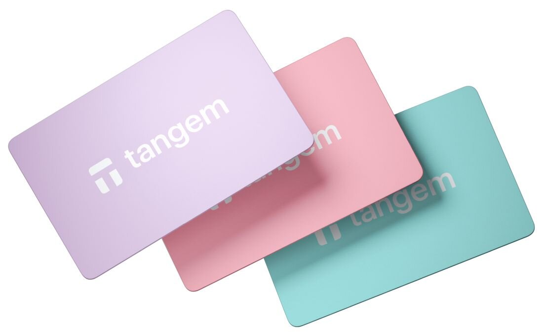 Trzy pastelowe karty Tangem w kolorach fioletowym, różowym i turkusowym leżą ułożone warstwowo na białym tle - Trwały format karty bankowej 
