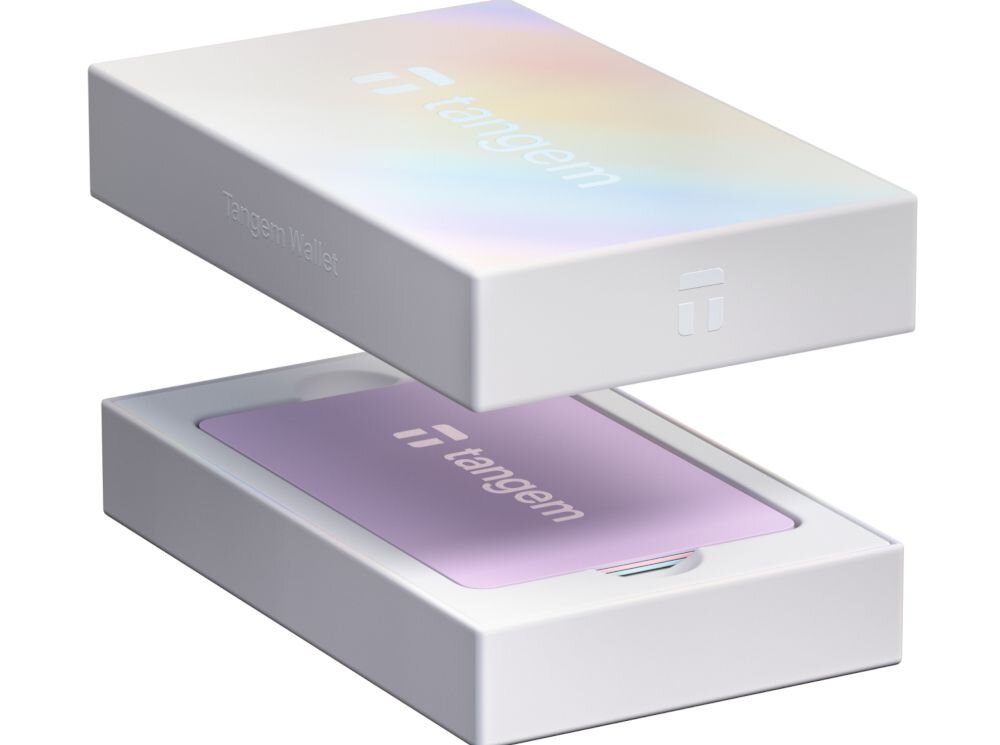Pastelowa karta Tangem leży w białym pudełku zestawu Tangem Wallet z uniesionym wieczkiem - Karta Tangem komunikuje się ze smartfonem wyłącznie przez NFC  