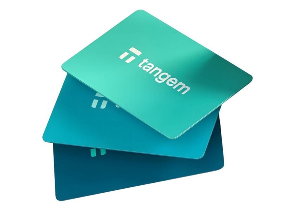 Trzy pastelowe karty Tangem w kolorach fioletowym, różowym i turkusowym leżą ułożone warstwowo na białym tle - Trwały format karty bankowej 