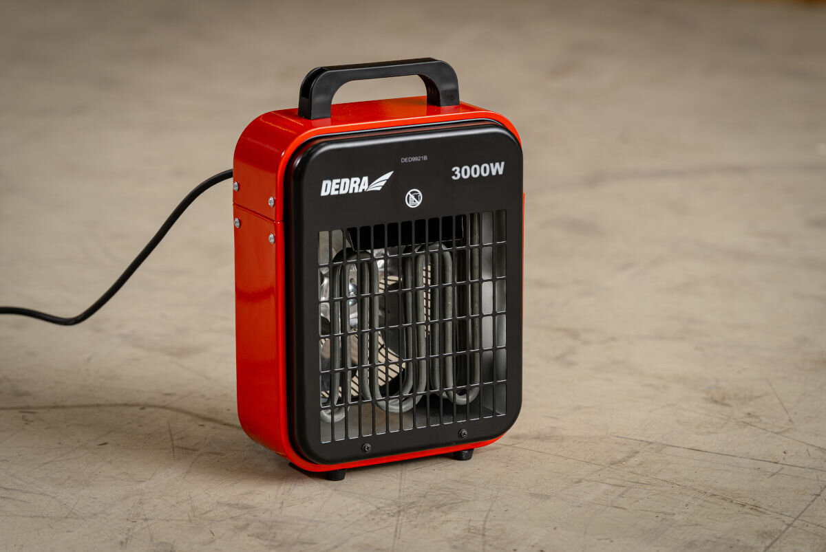 Nagrzewnica elektryczna DEDRA DED9921B, 3000W, 410m³/h, trzytryby, elastyczność, Przód nagrzewnicy DED9921B, czarna kratka, spirale grzewcze, uchwyt do przenoszenia.