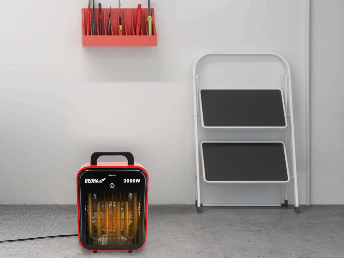 Nagrzewnica elektryczna DEDRA DED9921B, pomoc, remont, osuszanie, uniwersalność, Dedra DED9921B działa w warsztatowym wnętrzu – grzałki rozświetlone, dekor stylizowany.