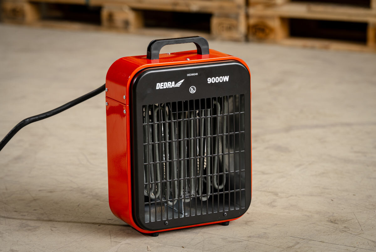 Nagrzewnica elektryczna DEDRA DED9924B, przegrzanie, IPX4, metal, stabilność, Dedra DED9924B na podłodze magazynu, podłączona, gotowa do dogrzewania przestrzeni.
