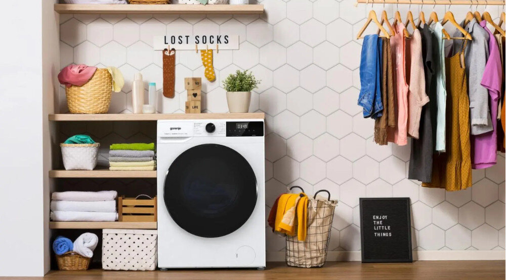 PRALKA GORENJE WNHAI84APS Pralka Gorenje ustawiona w domowej pralni obok półek z ręcznikami i ubraniami. Urządzenie dobrze komponuje się z zabudową