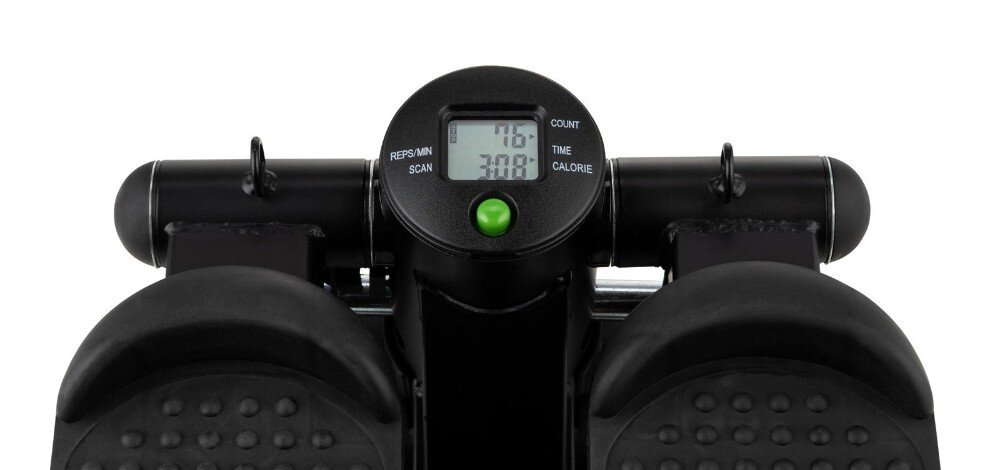 Czarny stepper z wyświetlaczem pokazującym wartości: 76 COUNT, 300 TIME, CALORIE. Widoczne są również dwa pedały z wypustkami oraz przycisk w kolorze zielonym.
