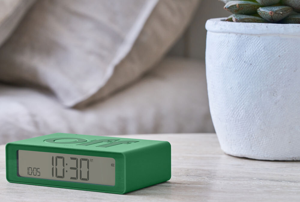 Budzik LEXON Flip Mini zielony, podróż, USB-C, bateria, ekran, Klasyczny Lexon Flip Mini z napisem „off”, matowa grafitowa obudowa, jasny blat, wyraźny ekran.