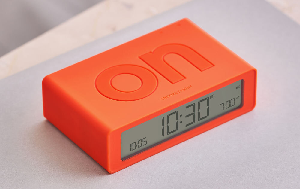 Budzik LEXON Flip Mini pomarańczowy, dwustronna, wygoda, komfort, sen, Lexon Flip Mini na jasnym blacie, napisy ON/OFF na górze, ergonomiczna, prosta forma, czytelność