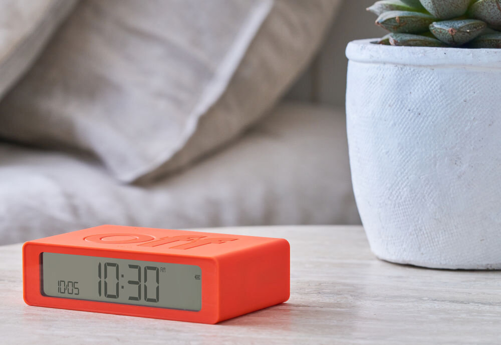 Budzik LEXON Flip Mini pomarańczowy, podróż, USB-C, bateria, ekran, Klasyczny Lexon Flip Mini z napisem „off”, matowa grafitowa obudowa, jasny blat, wyraźny ekran.