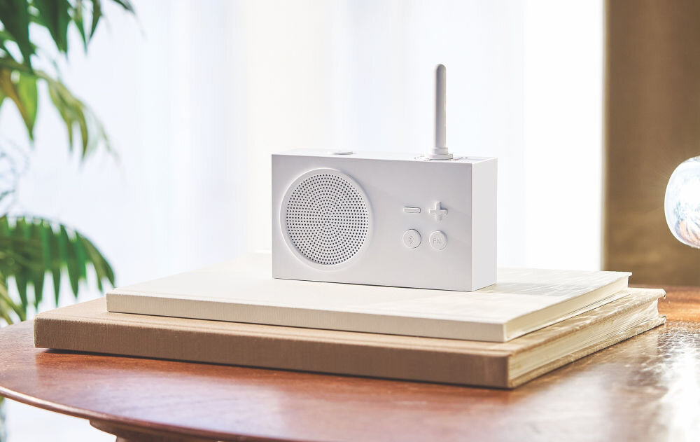Radioodtwarzacz LEXON Tykho 3 biały, radio, muzyka, funkcjonalność, Technologia,  Radio Lexon Tykho 3 stoi na jasnych książkach, roślina w tle, minimalistyczny wystrój.